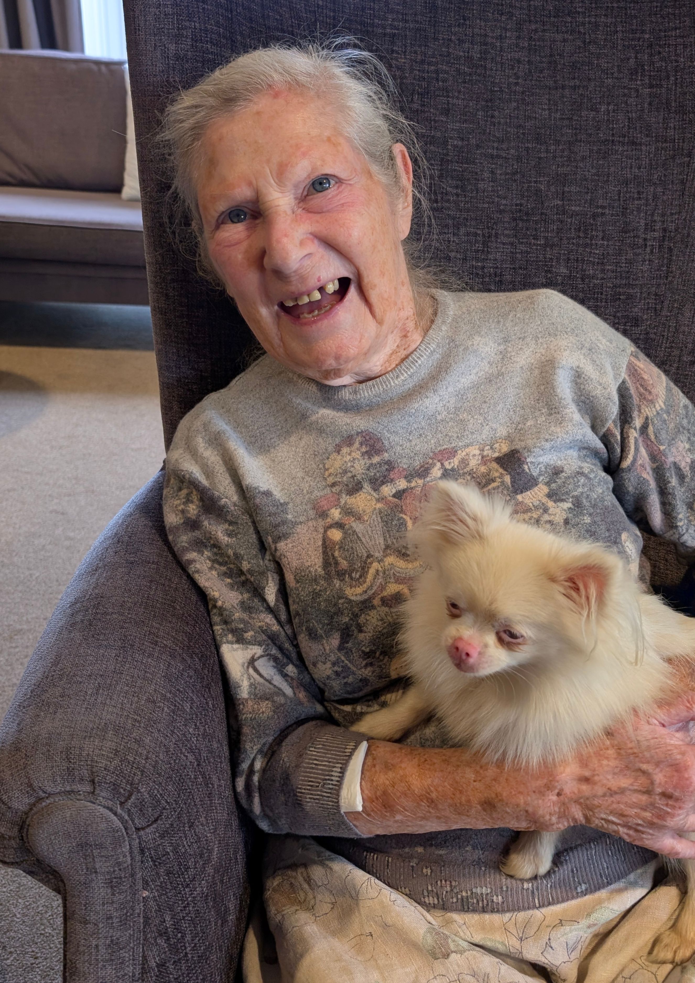 smiling resident with blonde pomeranian