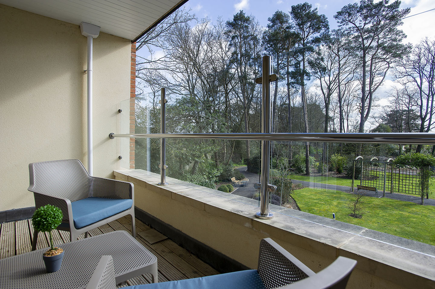 Private balcony at Upton Manor Care Home in Poole, overlooking landscaped gardens and surrounding trees