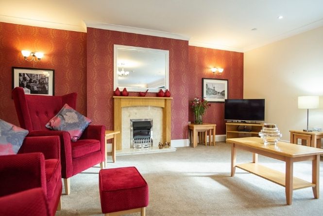 Comfortable lounge with fireplace at Caddington Grove